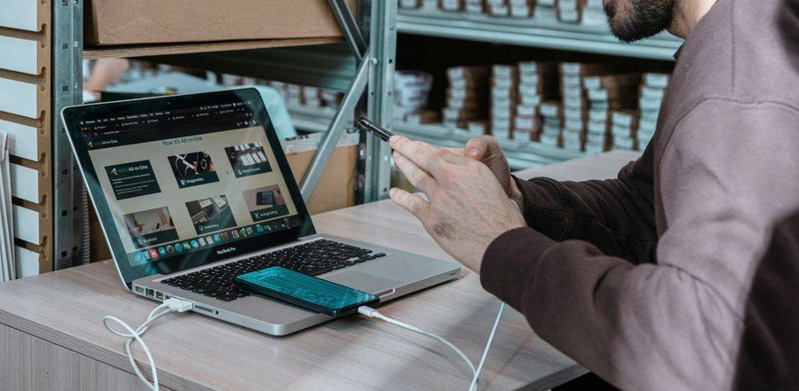 Arbeit mit Laptop und Mobiltelefon am Lagerarbeitsplatz